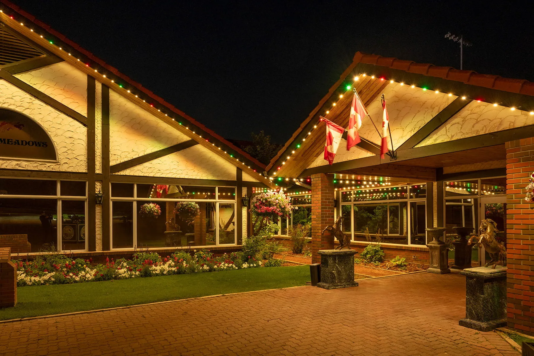 Timber-framed restaurant entrance with permanent lights at night