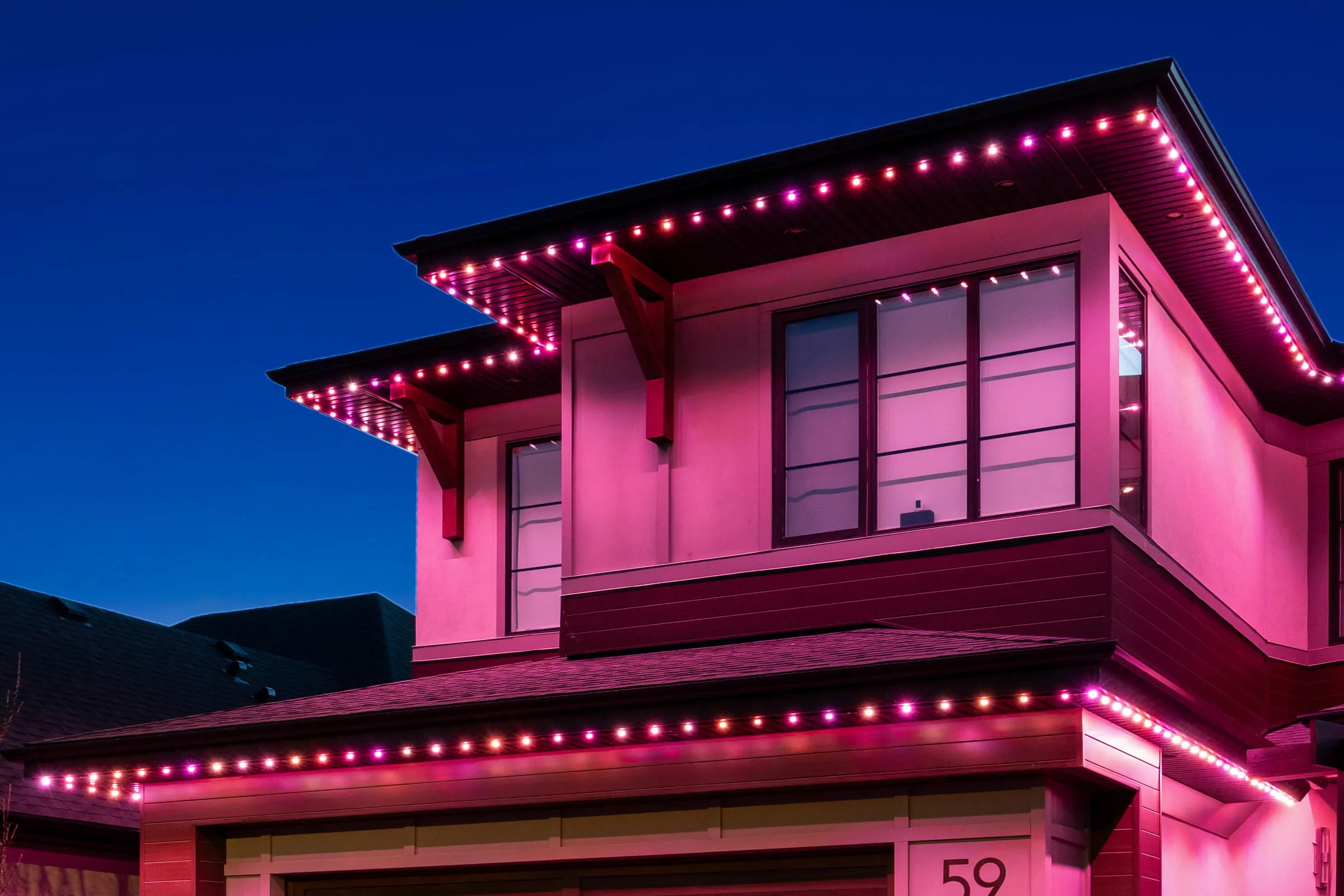 Two-storey home washed in pink Valentine's Day lighting