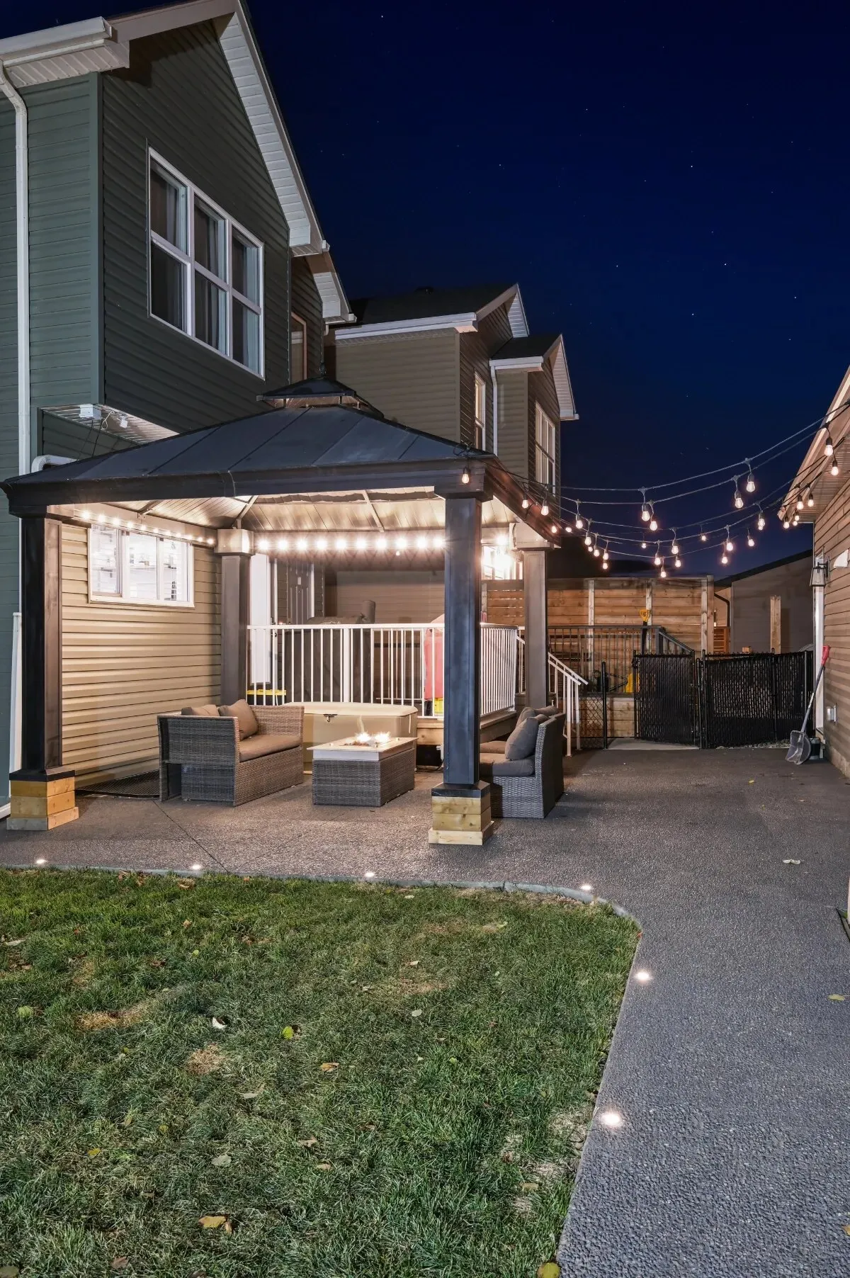 Backyard pergola with warm white Gemstone patio string lights at dusk