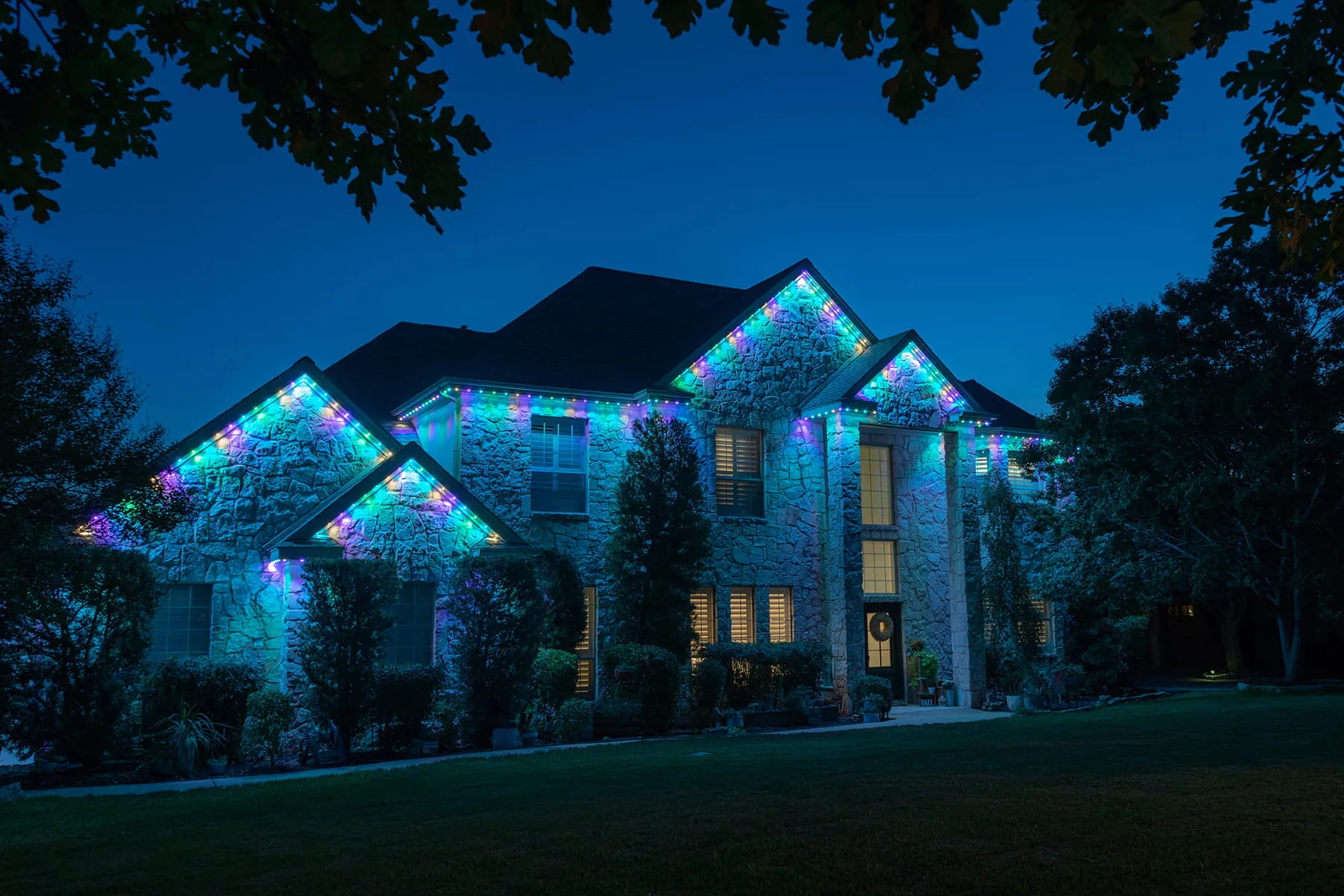 Large home with a teal and blue accent pattern along the roofline