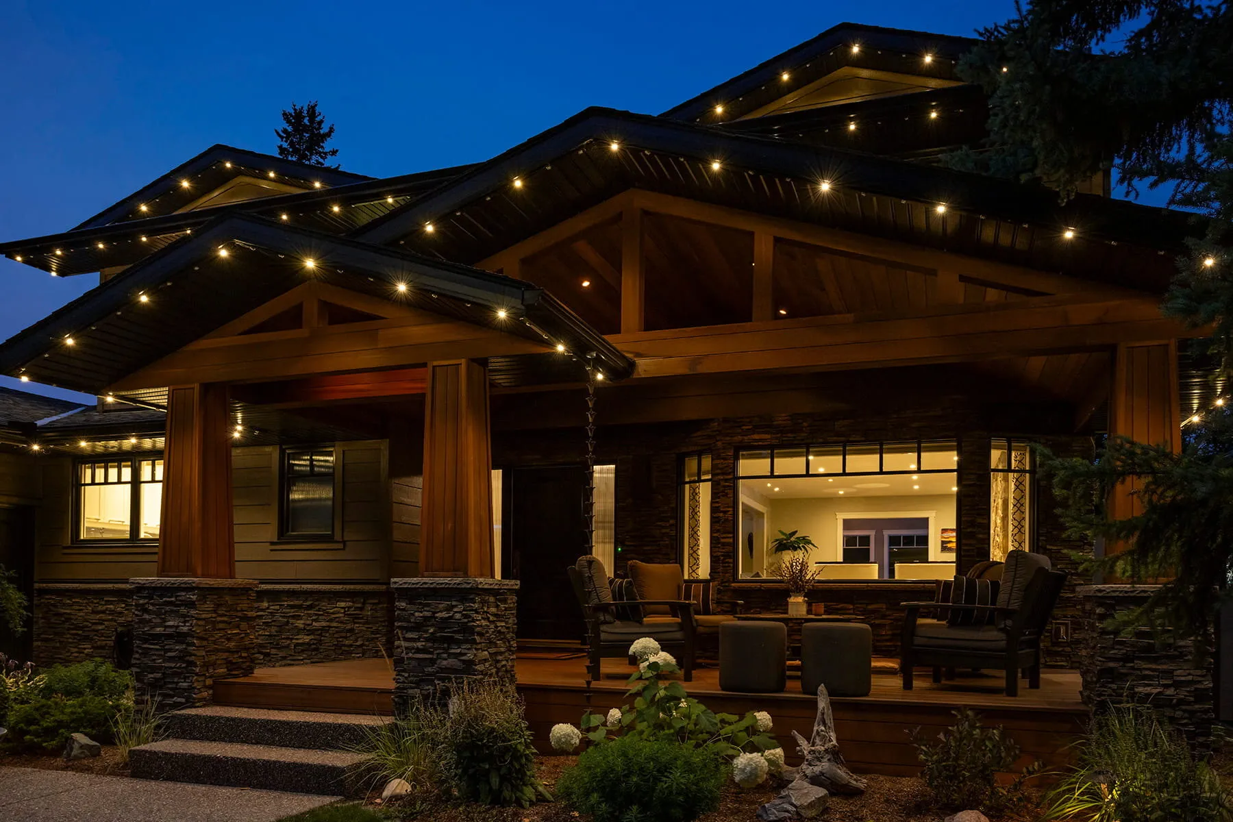 Craftsman home with warm white Gemstone permanent lights and a lit covered patio