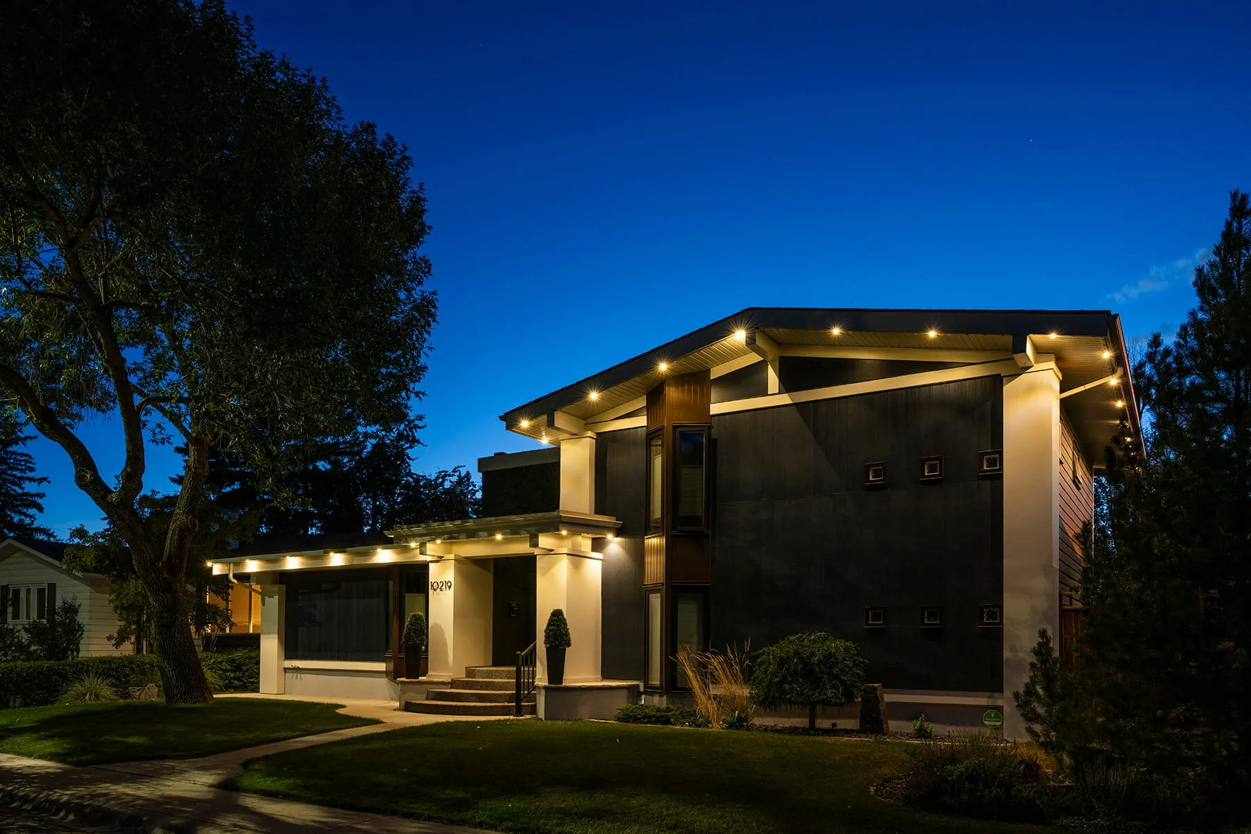 Modern home with warm white soffit lighting at blue hour